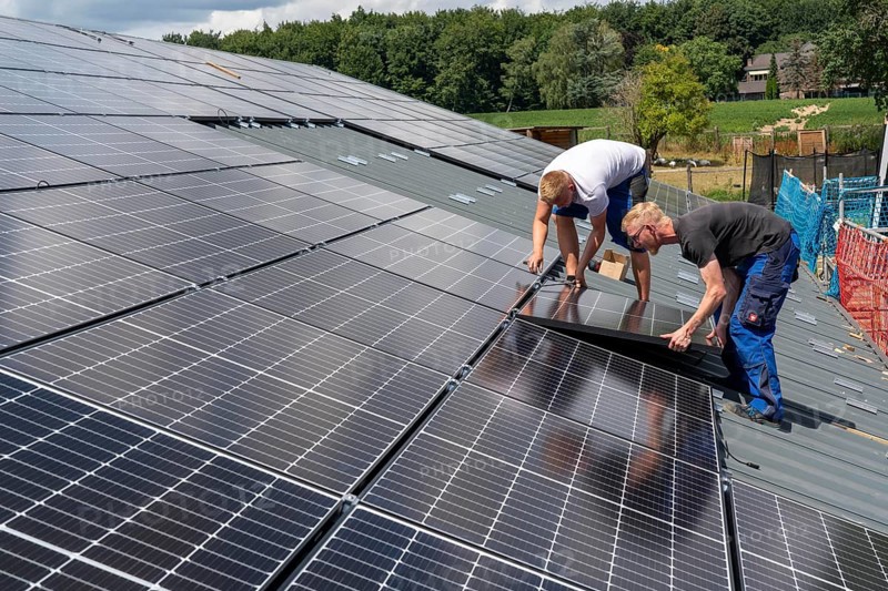 Installation of solar modules on the roof of a barn on a farm, over 210 photovoltaic modules are installed on the roof, North Rhine-Westphalia, Germany, Europe