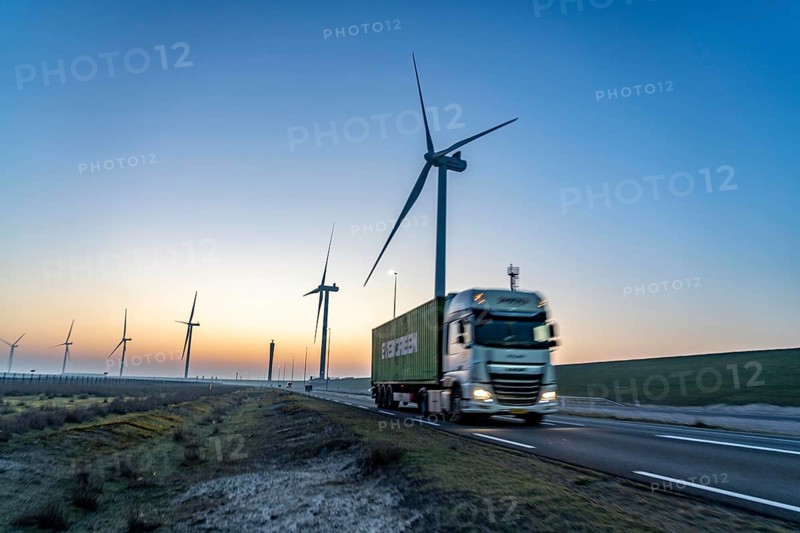 Lorry on the road to Euromax Terminal Rotterdam, ENECO wind farm on the dike around the port of Maasvlakte 2, 22 wind turbines with a capacity of 116 megawatts, sunset, Rotterdam, NetherlandsEvergreen Container