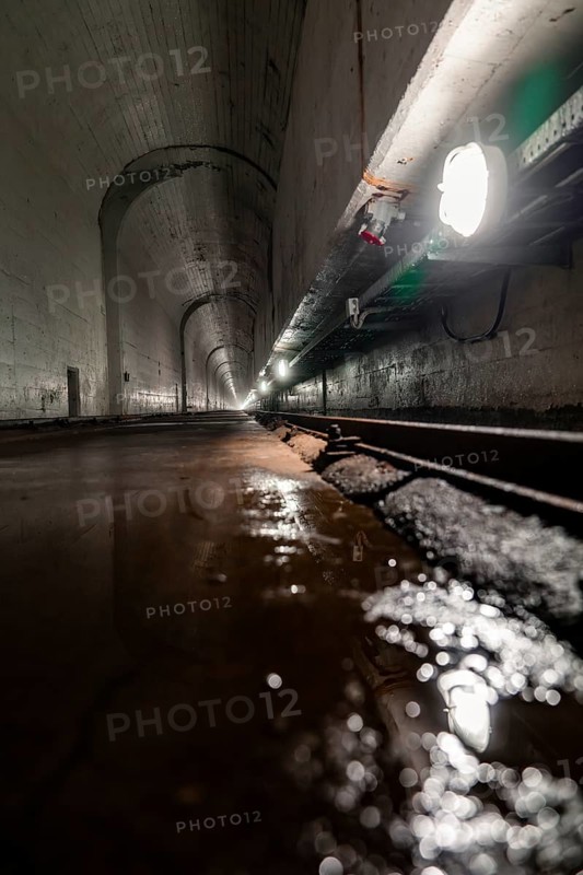 Long, dark tunnel with pools of water, concrete walls and light reflections, industrial atmosphere, Rappbode Dam, Harz Mountains, Germany, Europe