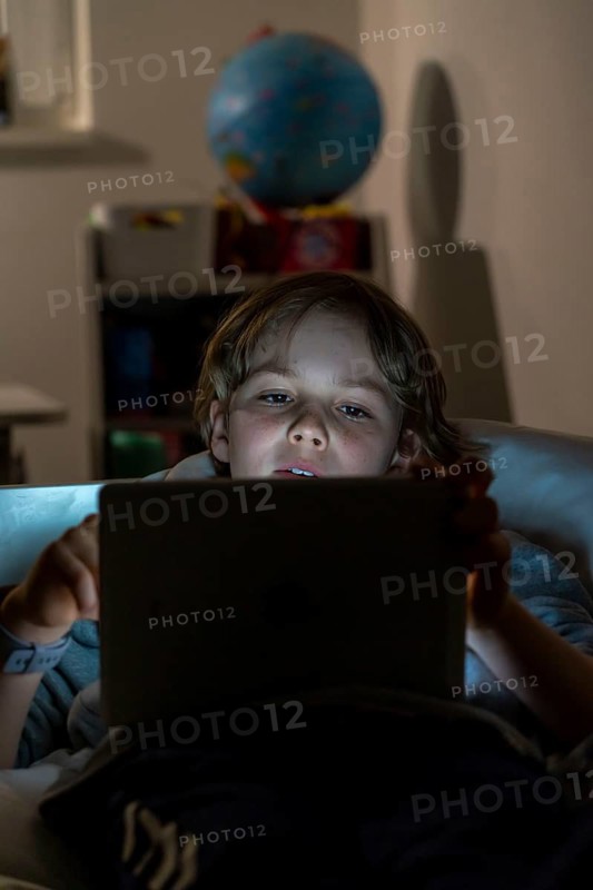 A boy plays computer games on a tablet PC