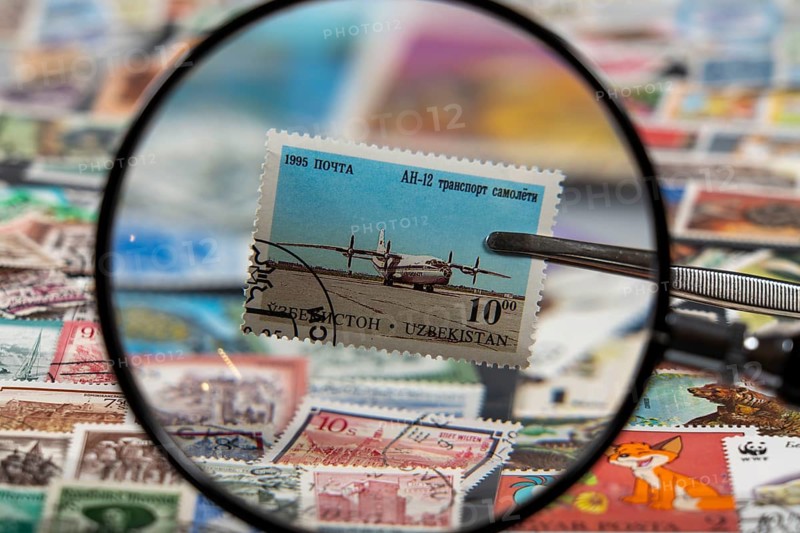 Stamp collection, collecting, postage stamps, postage stamps from different countries, magnifying glass, stamp with aeroplane from Uzbekistan, Antonov An-12