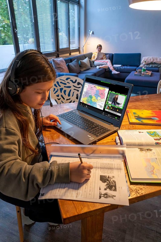 Homeschooling, 2 girls, sisters, 11 years old, learning at home, home learning, lessons at home, distance learning, chat with teachers and classmates via laptop, symbolic picture