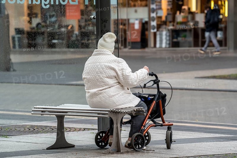 Bus stop, senior citizen with rollator waiting for the bus, Bochum, North Rhine-Westphalia, Germany, Europe
