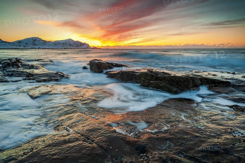 Long exposure, sunset in winter at Skagsanden, rocks washed over by the sea on the beach at Flakstad, Flakstadøy, Lofoten, Nordland, Norway, Europe