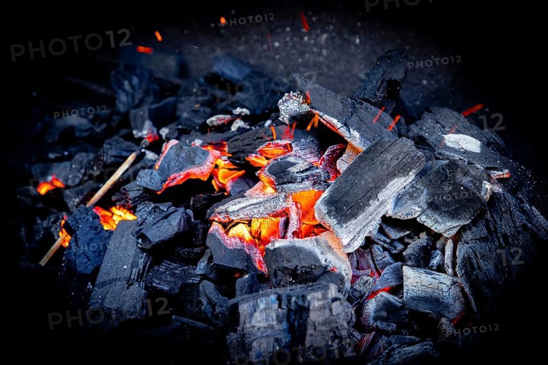 Close-up of glowing charcoal with glowing sparks