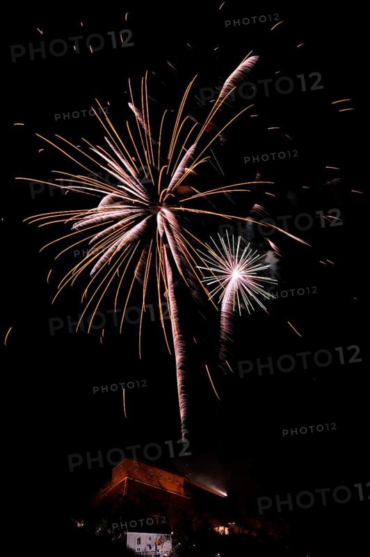 Fireworks light up the night sky above a building with glowing sparks, New Year's Eve, Stallbastei, Schlossberg, Graz, Styria