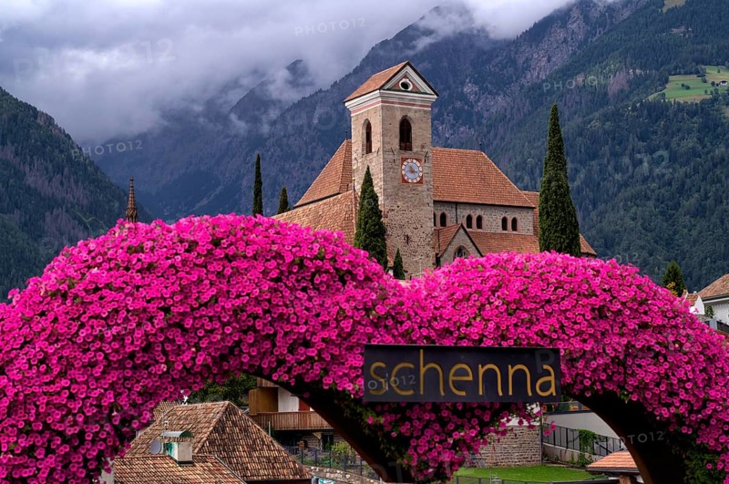 Photopoint, sign, flower heart, heart made of flowers, behind it the new parish church Maria Himmelfahrt, Schenna, Scena, South Tyrol, Autonomous Province of Bolzano, Italy, Europe