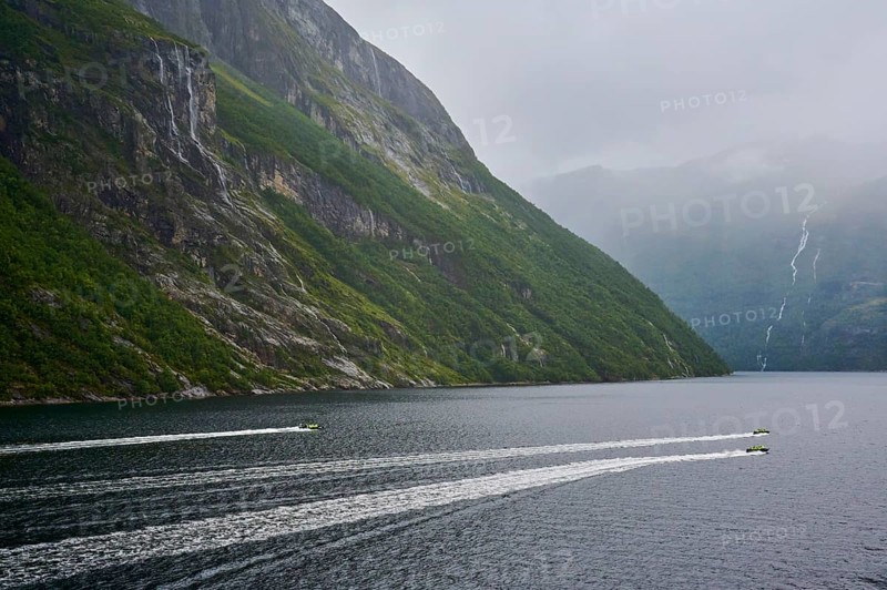 Two speedboats with groups of people travelling fast in the Geiranger Fjord, white waves are coming up behind them, Geiranger, Geiranger Fjord, Stranda, Romsdal, Norway, Europe