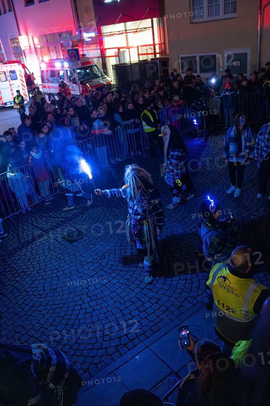 People gather at night on a street with glowing torches and security forces, carnival, Calw, Black Forest, Calw district, Germany, Europe