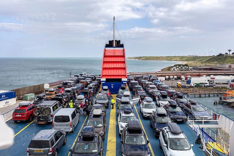 Ferry fully loaded with cars on the sea, in the background the coast and cloudy sky, Rosslare Harbour Ferry