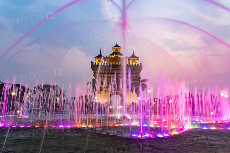Colourfully illuminated fountain at Patuxai Victory Gate at dusk, capital Vientiane, Laos, Asia