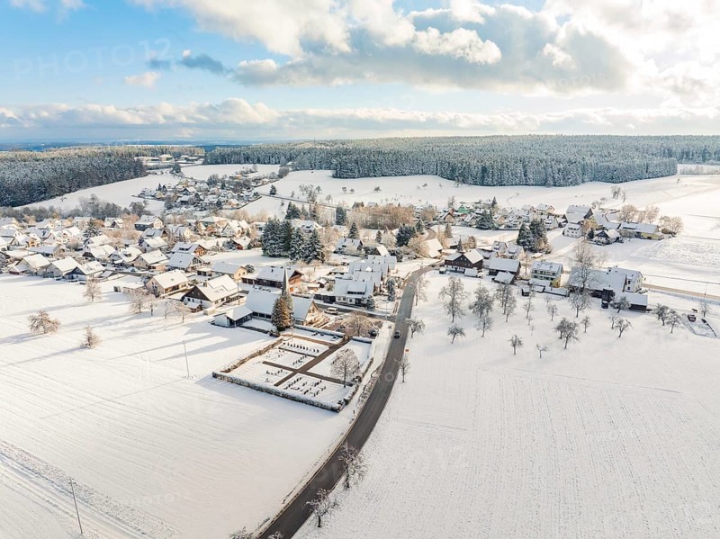 Snow-covered village with streets and buildings under a cloudy sky, Oberreichenbach, Black Forest, Calw district, Germany, Europe