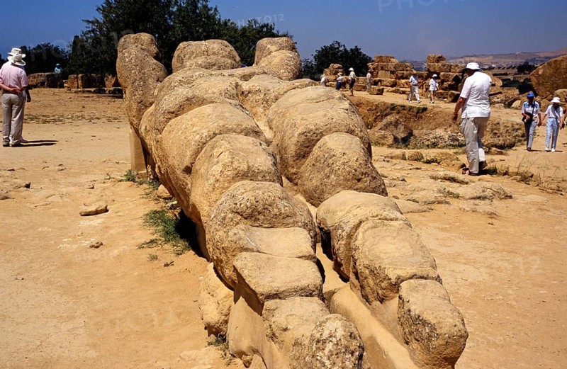 Tourists visiting the Greek ruins of the giant statue of Atlas or Telamon, Temple of Zeus, Akragas, Agrigento, Sicily, Italy 1999