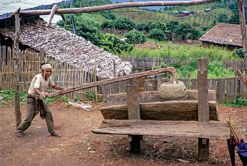 Man with an old grain pestle in a rural village, Northern Thailand, Asia 1971