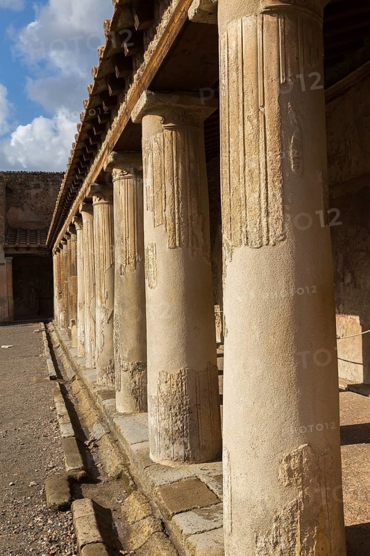 Old large building covered with terracotta clay roof tiles and supported by stone columns at the ancient ruins of Pompeii, Campania region, Italy, Europe