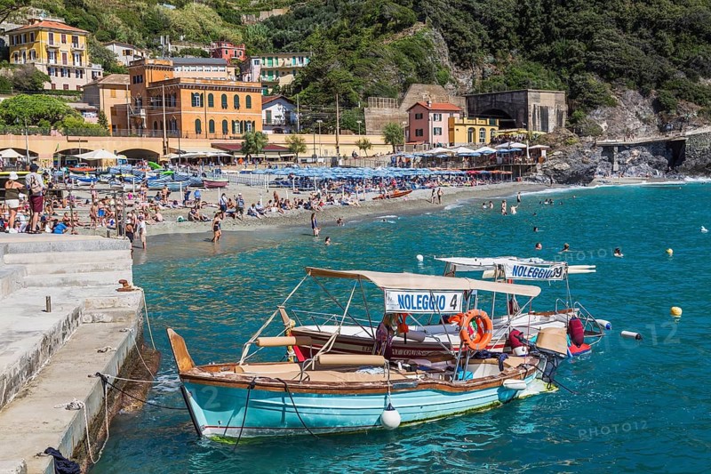 Moored turquoise, red tour boats fitted with canvas bimini tops in bay, Monterosso village, Cinque Terre, La Spezia province, Italy, Europe