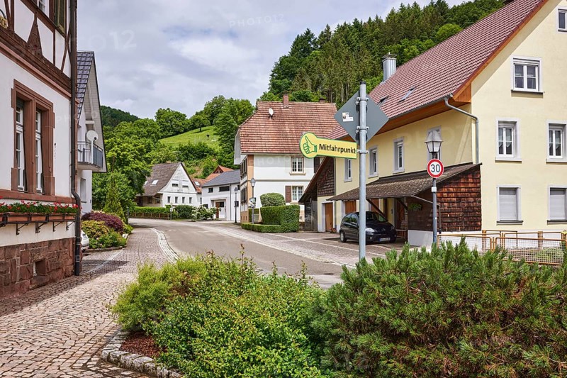 Carpooling point, multi-family houses, hilly landscape with coniferous forest, overcast sky with Nimbostratus clouds, sunlight, Bollenbacher Straße, Haslach im Kinzigtal, Black Forest, Ortenaukreis, Baden-Württemberg, Germany, Europe