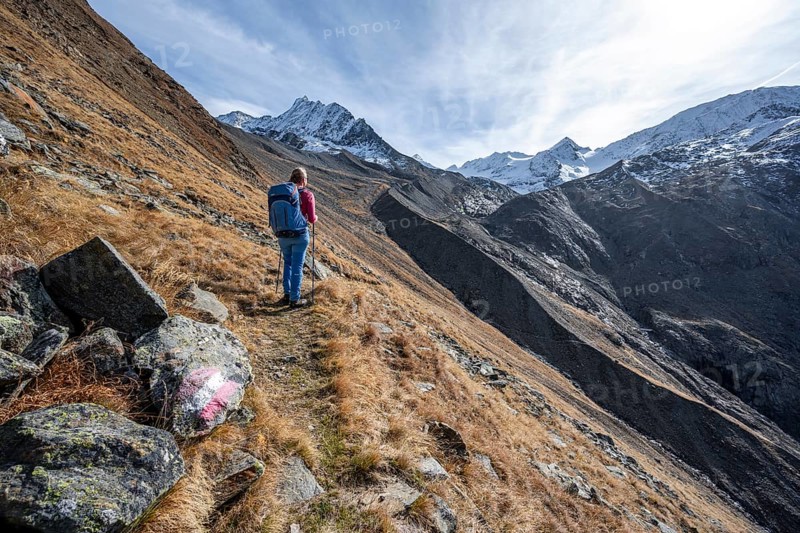 Mountaineer on a hiking trail in Niedertal, snow-covered mountain peaks of the Ötztal Alps with Finailspitze in the background, Ötztal Alps, Tyrol, Austria, Europe
