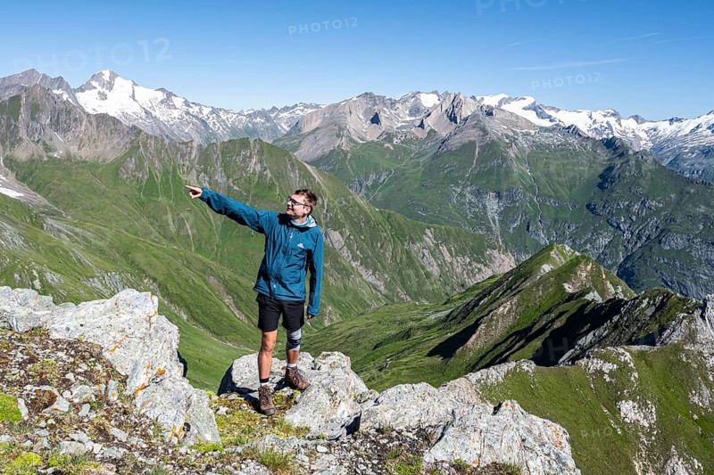 Mountaineer points into the distance, in front of mountain panorama with Großvenediger, mountain landscape with mountain peaks of the Venediger group, view from the summit of the Gösleswand, Lasörling group, Hohe Tauern National Park, East Tyrol, Tyrol, Austria, Europe