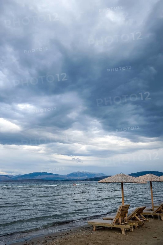 Kalamaki, Corfu, Greece, Sun loungers and parasols on Kalamaki beach in the north-east of the Greek island of Corfu. Back mainland Albania, Europe