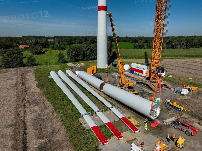 Dorsten, North Rhine-Westphalia, Germany, construction of a wind turbine, the first wind turbine of the Grosse Heide wind farm. The rotor blades are ready for assembly. A large mobile crane places the tower elements, the rings, on top of each other. This wind turbine will have a rated output of 5, 500 kW, Europe