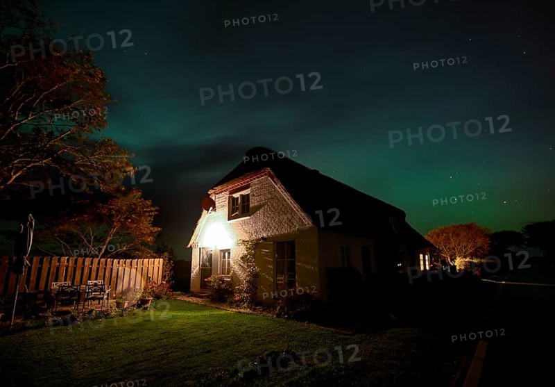 Northern Lights (Aurora borrealis) over a thatched roof house, Junkersmitteldeich, Pellworm Island, Schleswig-Holstein Wadden Sea National Park, North Frisia, Germany, Europe