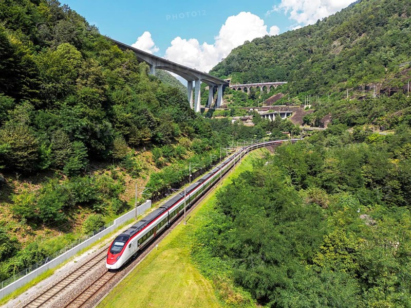 Railway passenger train of the type Stadler Flirt of the Südostbahn on the Gotthard railway Aerial view in the Alps in Giornico, Switzerland, Europe