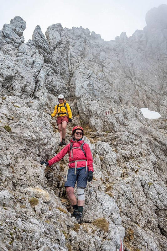 Two mountaineers with helmets climbing on a rock face, ascent to the Ackerlspitze, Wilder Kaiser, Kaiser Mountains, Tyrol, Austria, Europe