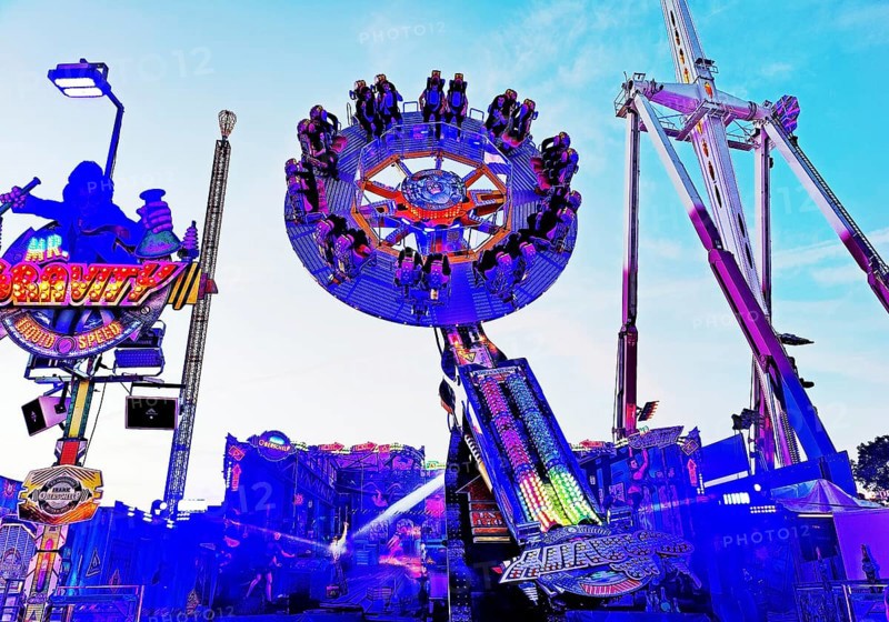People on the illuminated carousel Mr Gravity in the evening, Cranger Kirmes, Herne, Ruhr area, North Rhine-Westphalia, Germany, Europe