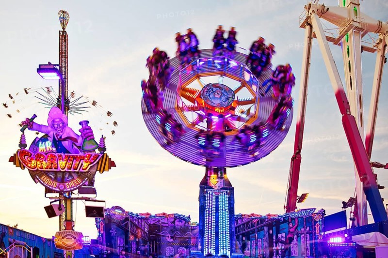 People on the illuminated carousel Mr Gravity in motion, Cranger Kirmes, Herne, Ruhr area, North Rhine-Westphalia, Germany, Europe