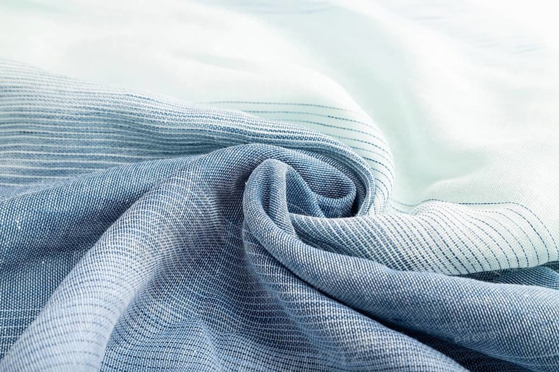 Fragment of blue linen tissue. Side view, natural textile background and texture. wave concept, abstract, spiral