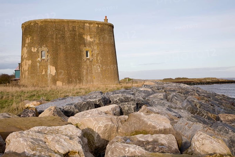 Martello tower defended from erosion by rock armour at East Lane, Bawdsey, Suffolk, England, United Kingdom, Europe