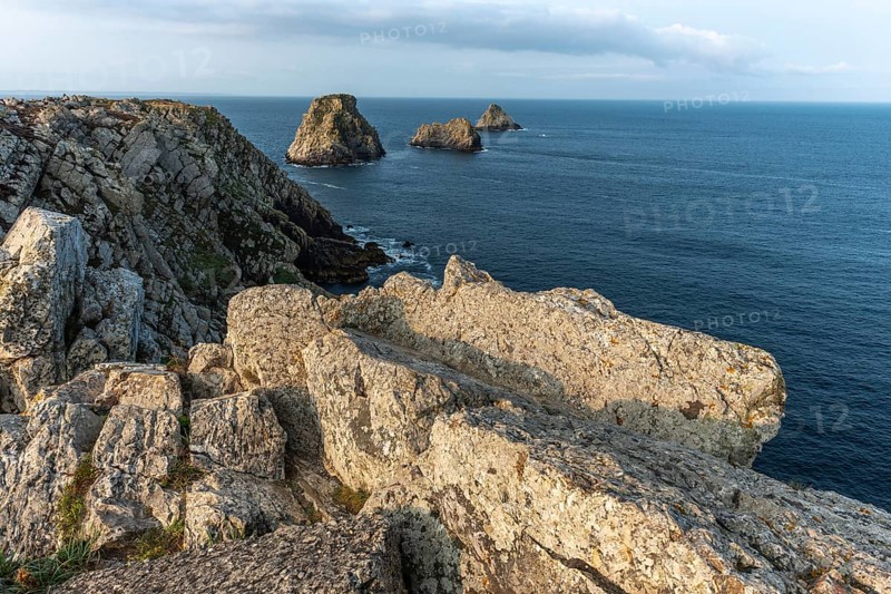 The tip of Pen Hir and its peach stacks. The rocks are jagged and rough, while the water is calm. The scenery is peaceful. Camaret sur mer, Crozon, Finistere, France, Europe