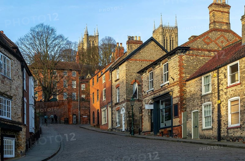 Cathedral towers rising above buildings, Steep Hill in evening light, Lincoln, Lincolnshire, England, UK