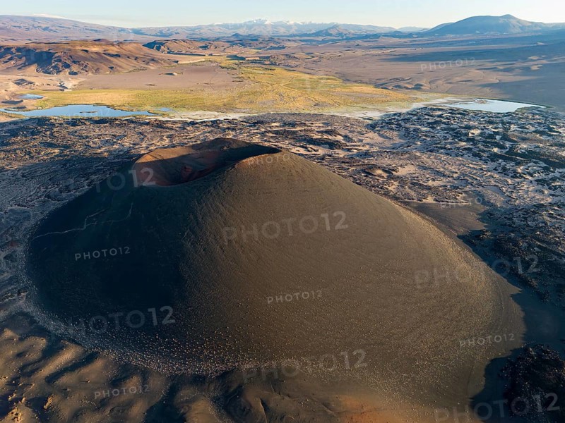Aerial view of a large volcanic crater in the middle of a barren desert landscape, Argentina, volcanoes, lava field, Antofagasta, South America