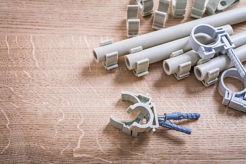 Aerial View Big Composition Polypropylene Fixators And Pipe With Clips On Wooden Board