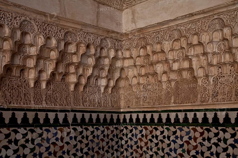 Nasrid palace, stucco wall decoration over tiled plinth in a corner of the room