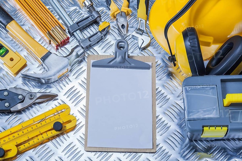 Clipboard with white sheet of paper and set construction tools
