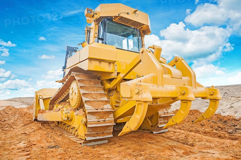 Bulldozer yellow coloured standing on sand rear view