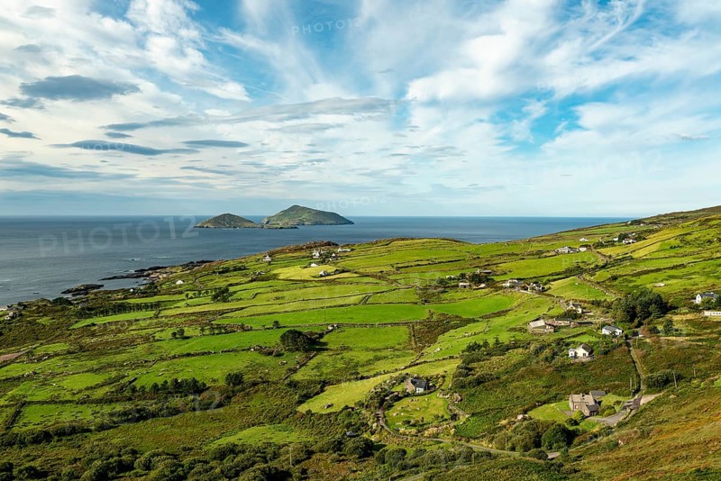 Wide Irish coastal landscape at the RIng of Kerry near Caherdaniel, with green fields and a view of the sea with two small islands (Scariff and Deenish) on the horizon, Iveragh Peninsula, County Kerry, Ireland, Europe
