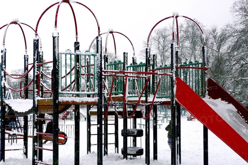 Snowstorm covering playground in park, London, UK United Kingdom England