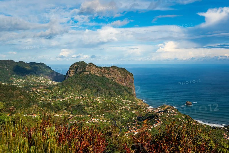 View of the Penha d'Águia (Eagle Rock) and the surrounding coastal landscape with lush greenery and deep blue ocean, Madeira, Portugal, Europe