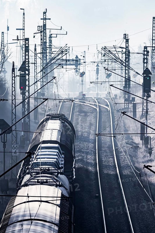 Deutsche Bahn AG tracks backlit with goods train. Overhead line, signals and infrastructure. Railway tracks at the Geislinger Steige, Alb ascent to the Swabian Alb. Amstetten, Baden-Württemberg, Germany, Europe