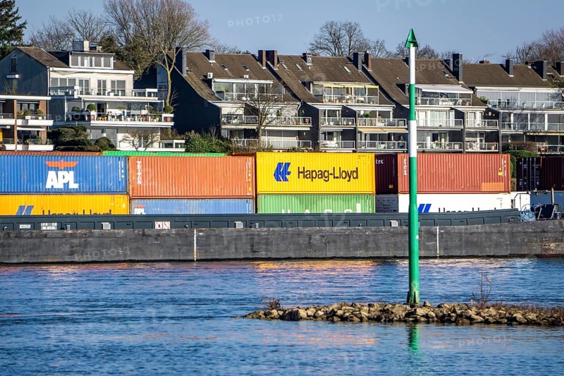 Container cargo ship on the Rhine near Düsseldorf-Bockum, villas on the banks of the Rhine, the neighbourhood in district 5 is one of the most expensive residential areas in Düsseldorf, North Rhine-Westphalia, Germany, Europe