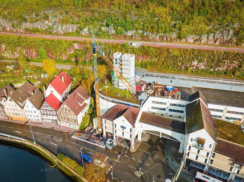 Crane on construction site next to concrete tower and multi-storey buildings in urban environment, extension of the ZOB Calw tower onto the new track of the Hermann Hesse railway, Calw, Black Forest, Germany, Europe