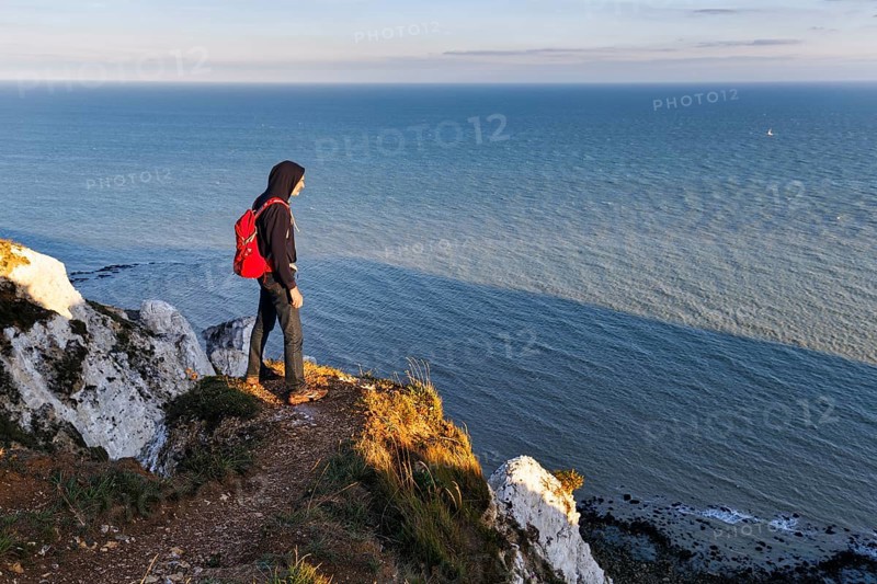 Hiker enjoying views of cliffs, chalk coast, Beachy Head, Eastbourne, South Downs, Sussex, England, United Kingdom, Europe