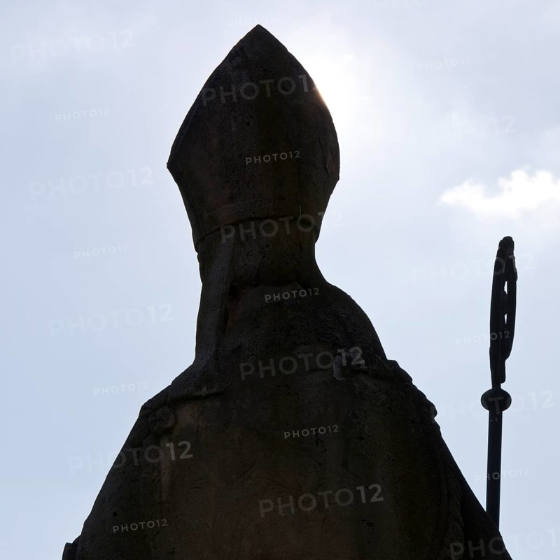 Statue of Bishop Boniface with mitre and crozier against the light, Freckenhorst, Münsterland, North Rhine-Westphalia, Germany, Europe