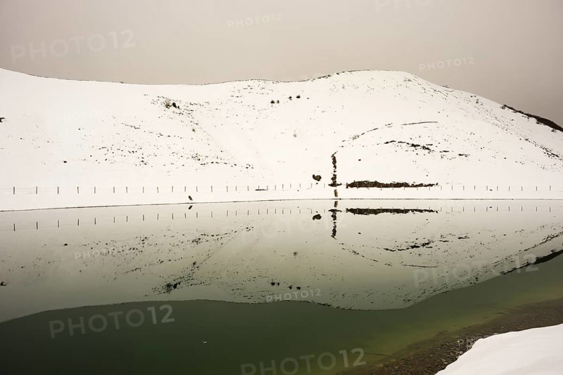 After snowfall in May: Riezler Alpsee, an artificial lake, snow pond, feeds the snow cannons that completely cover the slopes of the Fellhorn and Kanzelwand cable cars with snow, Allgäu Alps, Vorarlberg, Austria, Europe