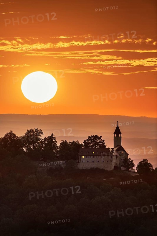 Teck Castle in front of a dramatic orange sunset on a hill, near Kirchheim unter Teck, Swabian Alb, Baden-Württemberg, Germany, Europe