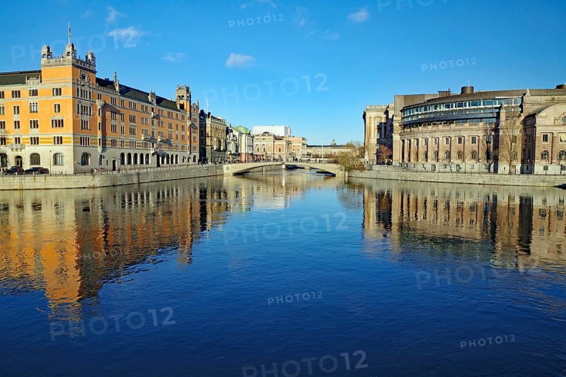 Symmetrical view of a river with bridge and city buildings, Riksdag, capital city, Stockholm, Sweden, Europe